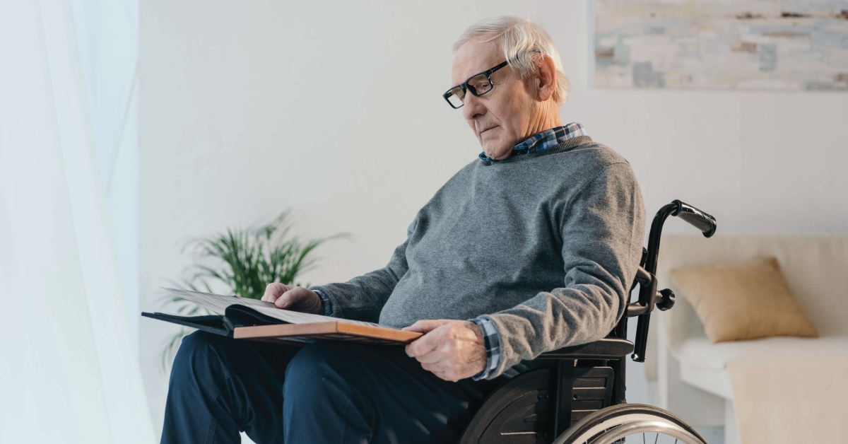 Elderly Man in Wheelchair Reading